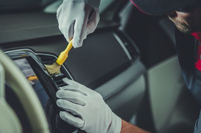 Close-up of man cleaning car with brush