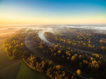 Aerial view of river in forest against sky during sunset