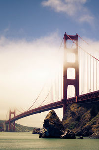 View of suspension bridge against cloudy sky
