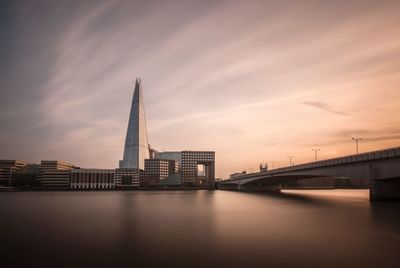 Bridge over river against buildings in city