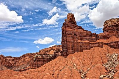 Low angle view of rock formations against cloudy sky