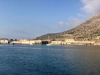 Scenic view of sea by buildings against sky
