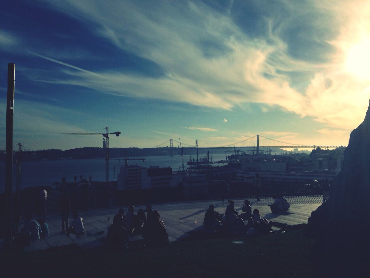 sky, transportation, sunset, cloud - sky, mode of transport, large group of people, silhouette, built structure, architecture, cloud, cloudy, lifestyles, men, travel, water, sunlight, person, outdoors, incidental people