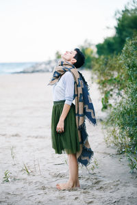 Woman with eyes closed while standing at beach