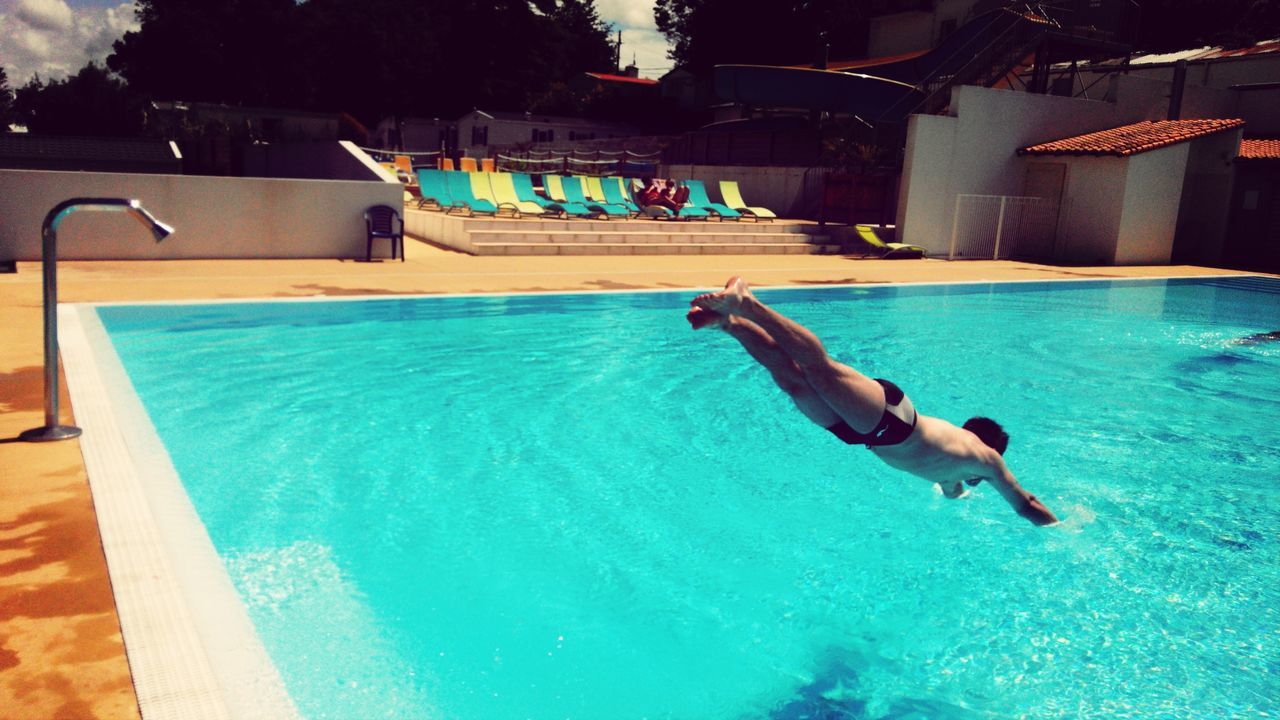 swimming pool, leisure activity, lifestyles, water, full length, blue, barefoot, sea, enjoyment, fun, vacations, jumping, men, shirtless, person, architecture, mid-air, motion