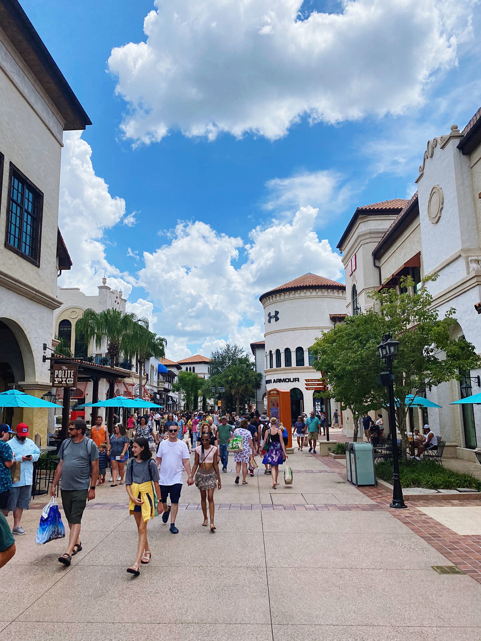 PEOPLE WALKING ON STREET BY BUILDINGS AGAINST SKY