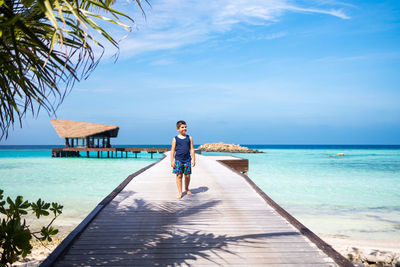 Little kid walking on a pathway over the ocean