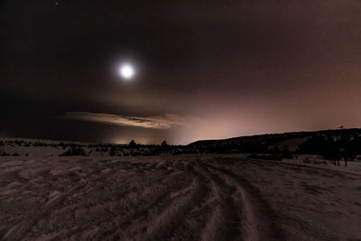 Scenic view of snowy field against sky at night