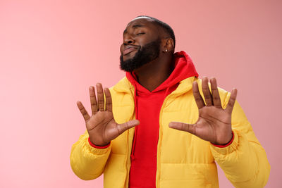 Man looking away while standing against colored background