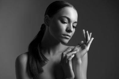 Side view of young woman against black background