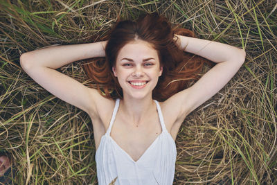 Portrait of a smiling young woman lying on grass