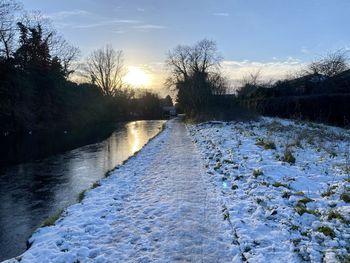 Scenic view of frozen canal against sky during winter