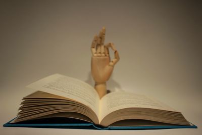 Close-up of open book with figurine against gray background