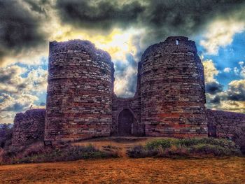 Low angle view of old ruin against cloudy sky