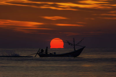 Silhouette boat in sea against sunset sky
