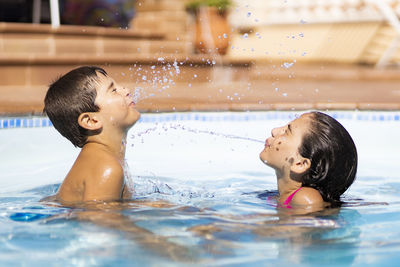 Portrait of boy and girl  in swimming pool