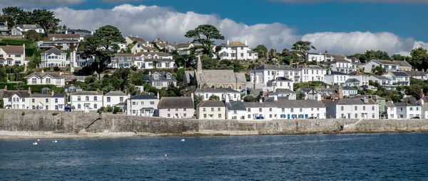 Houses in town by sea against sky