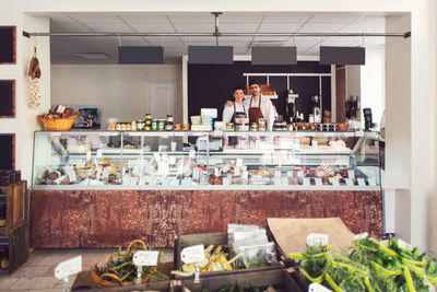 Portrait of confident owners standing in grocery store