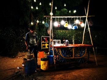 People working on illuminated tree at night