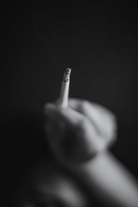 Close-up of hand holding cigarette