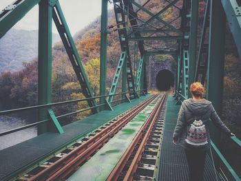 Rear view of woman walking on railway bridge