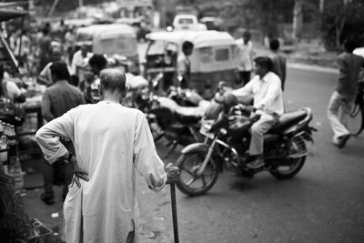 Rear view of senior man with walking cane standing on street