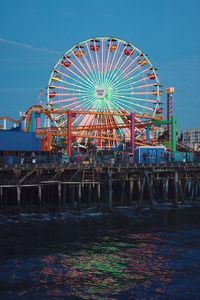 Illuminated ferris wheel against clear sky