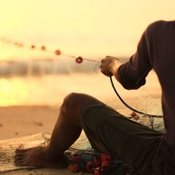 Cropped image of fisherman at sunset