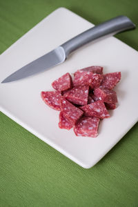 Close-up of chopped red meat with knife on cutting board