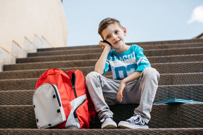 Full length of boy sitting outdoors