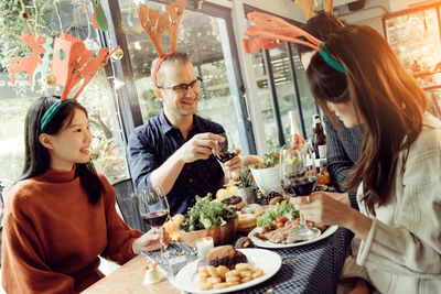 Friends having food and drink at table in restaurant