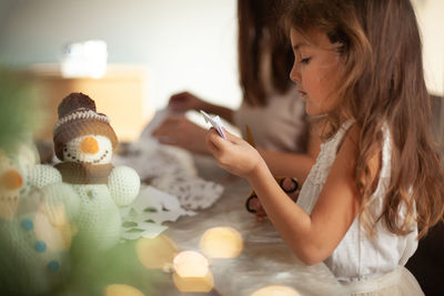 Midsection of woman holding smart phone at home