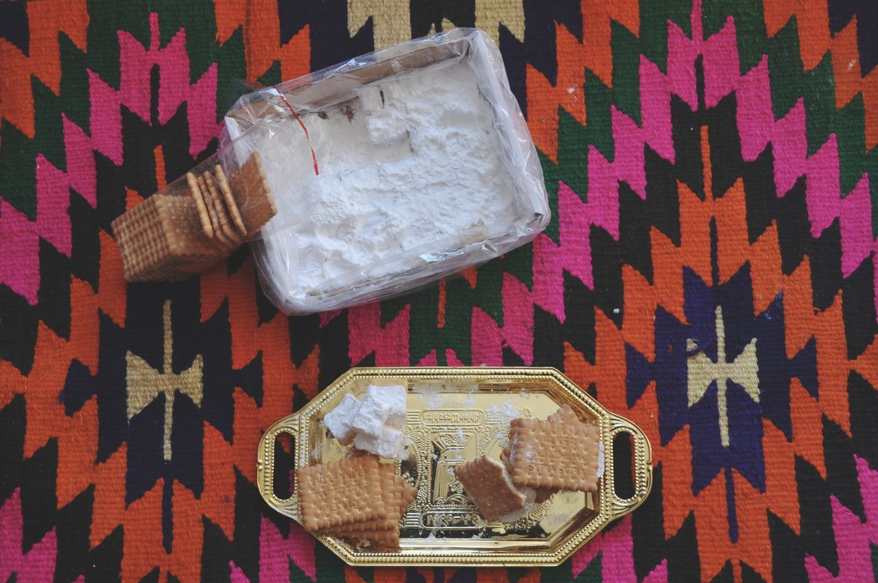 no people, indoors, high angle view, food and drink, table, still life, food, close-up, communication, textile, container, text, dessert, sweet food, paper, directly above, tablecloth, pattern, bag, newspaper, package, plastic bag, temptation