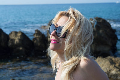 Portrait of woman wearing sunglasses at beach