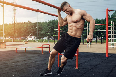 Full length of muscular man exercising at park