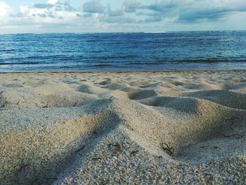 Close-up of sand on beach against sky