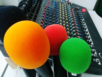 Close-up of multi colored microphones by audio equipment on table