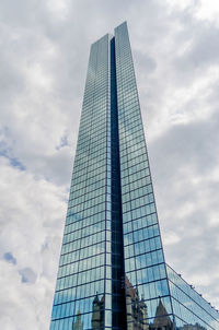 Low angle view of modern building against cloudy sky