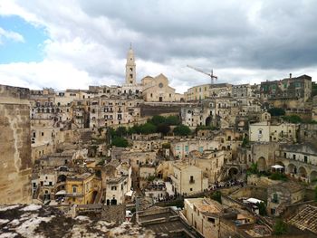 Buildings in city against cloudy sky