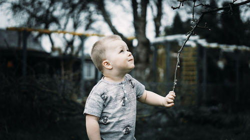 Side view of boy holding twig 