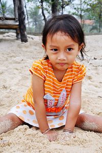 Portrait of cute girl sitting on land