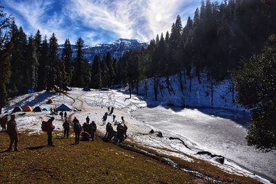 Panoramic view of people on snowcapped mountains against sky