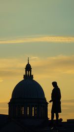 Rear view of silhouette man standing against sky during sunset