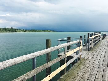 Wooden pier on sea against sky