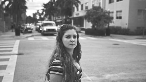 Portrait of woman standing on street in city