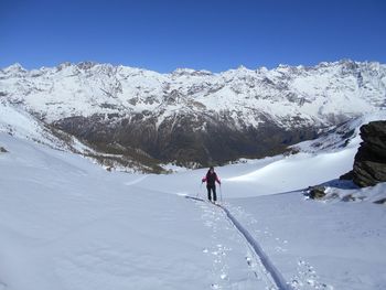 Full length of person skiing on snow covered field against clear sky