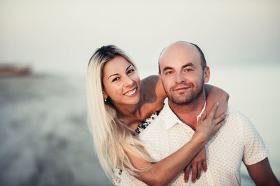 Happy young couple enjoying on a sandy beach at sunset.