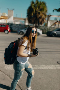 Young woman wearing sunglasses on street in city