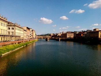 Ponte vecchio over river amidst buildings against sky