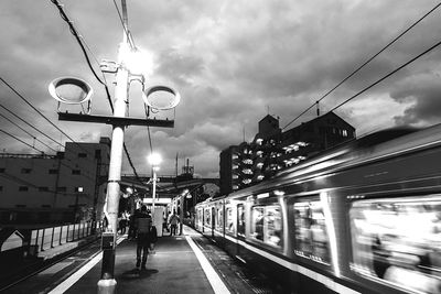 Railroad tracks against cloudy sky